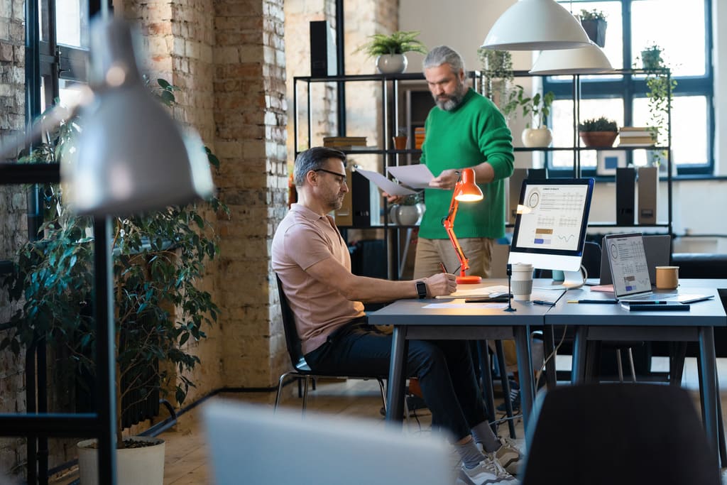 two-businessmen-cooperating-each-other-modern-office-using-laptop-documents-they-preparing-presentation